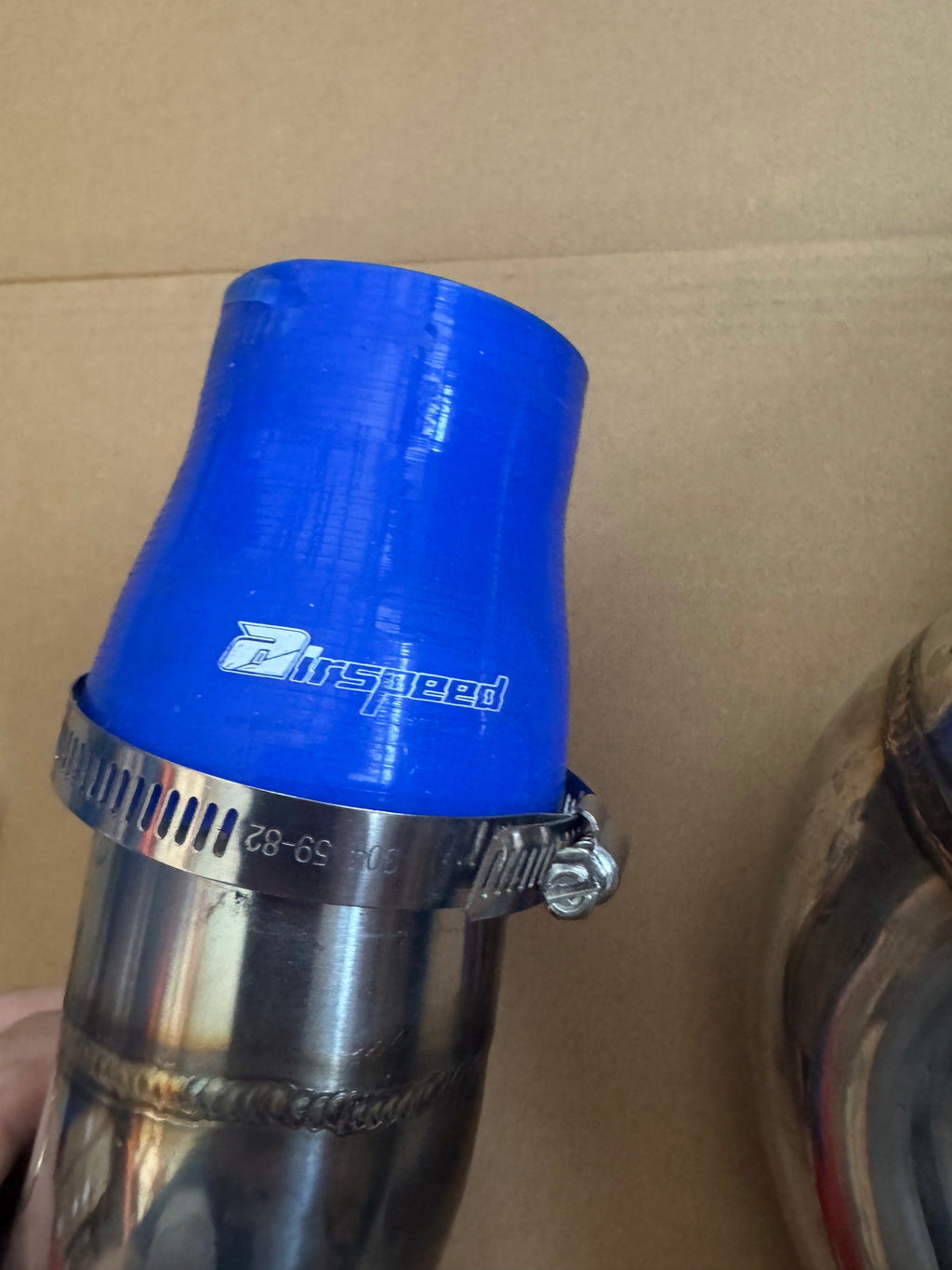 Close-up of blue coupler and clamp on charge pipe